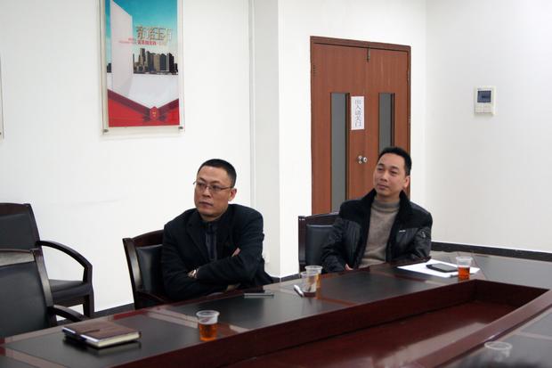 图5、云顶集团抛光砖销售副总张彦（左一）、云顶集团广东线销售副总庞永江（右一）认真寓目参评专卖店幻灯片播放效果