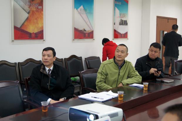 图6、寓目幻灯片的同时，，，，，，云顶集团仿古砖副总曹坚贞（右一）特殊用手机记下专卖店装修效果的差别亮点